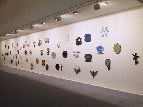 石本藤雄展 布と陶 －冬－ 壁に並べられた花の陶